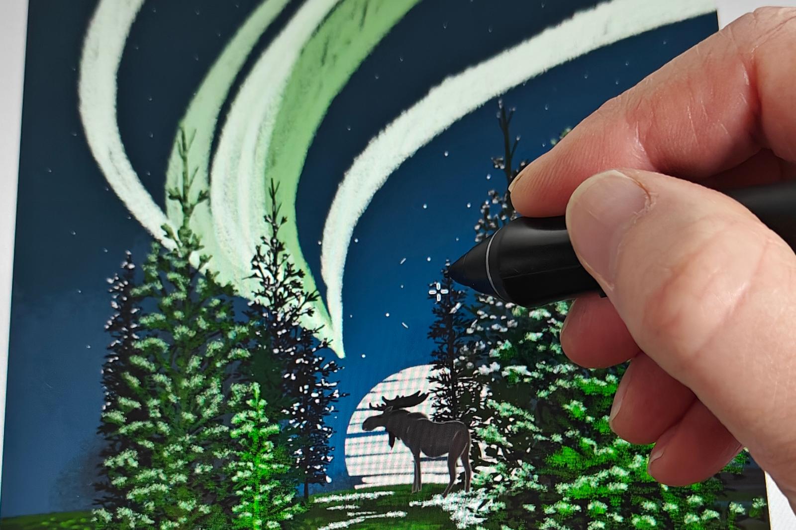 Hand drawing the northern lights on a tablet: green aurora over snowy pines with a moose, the Hidden Moose illustration in progress
