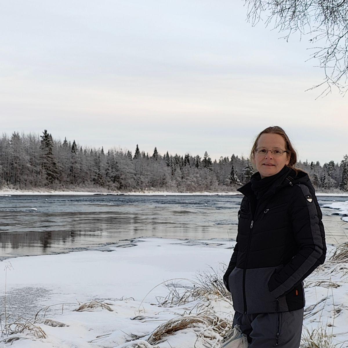 Wandelen langs een snelstromende rivier tijdens eerste sneeuw in Fins Lapland
