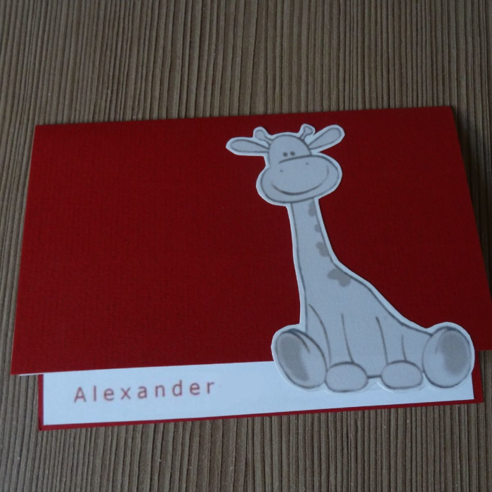 Rood geboortekaartje met handgeknipte lichtgrijze giraf en de naam Alexander