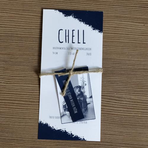 Donkerblauw en wit geboortekaartje voor Chell, afgewerkt met touwtje en labeltje